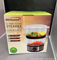 Front of product box showing brand Brentwood and product image of 2 tier food steamer with vegetables and salmon steaming inside. Highlights 5 quarts capacity, 60 minute timer, dishwasher safe parts and BPA free.