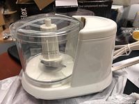 Proctor Silex food chopper unit showing transparent 1.5 cup bowl and white motor base with attached power cord.