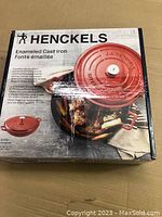 Box showing brand and product details with image of the red enameled cast iron sauteuse pot on the front.
