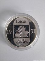 Front side of the 1991 Labatt Canada Cup silver coin showing 'Labatt', '1991', and 'Coupe Canada Cup' text with shield design.