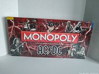 Front view of sealed AC/DC Collector's Edition Monopoly box showing band members and lightning graphics