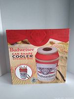Front and side of boxed Budweiser can shape cooler speaker bag showing the product image and branding.
