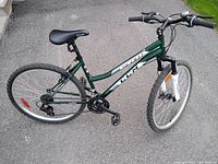 Full view of the green CCM Scout mountain bike showing the frame, rear and front tires, saddle, handlebars, and pedals.