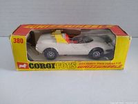 Photo of the die-cast model car inside original yellow and red Corgi Toys Whizzwheels box, showing car details and box condition.