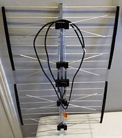 Full view of rectangular HD digital antenna with multiple metal rods and attached coaxial cable, used for receiving over-the-air TV signals indoors or outdoors.