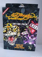 Front view of sealed Ed Hardy Tattoo Pack box featuring tiger and skull artwork, indicating the combo pack includes mouse pad, USB drive, and optical mouse.