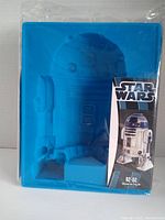 Blue silicone mold shaped as R2-D2 with packaging showing Star Wars branding and R2-D2 image.