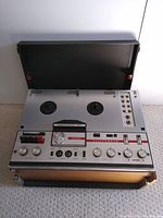 Top angled view of the Telefunken Magnetophon 204 showing dual reel spindles, control buttons, knobs, switches, and wooden side panels