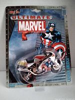 Front view of the sealed package showing Captain America Ducati Supersport 900FE diecast motorcycle with branding and illustration on card backing.