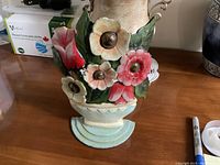 Photo showing the front view of the floral cast metal door stop with colorful flowers and leaves.