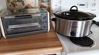 Both CrockPot slow cooker and Black & Decker toaster oven on counter showing condition and overall appearance.