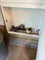 Overall view of woodworking hand planes and polishing tools in small built-in compartment.