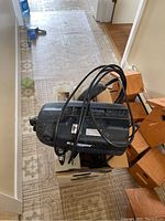 Side view of black Stinger electric pressure washer with power cord wrapped around it, showing the logo and vents.