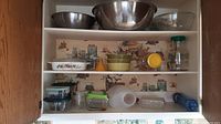 View of kitchen shelf with all glassware and bowls arranged, showing all items included in the set