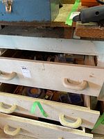 Drawers open showing assorted tools and hardware packed inside, including metal parts and containers