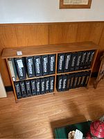 Wide shot of wooden shelving unit holding multiple black Canadian Workshop magazine binders.