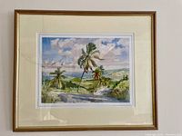 Framed watercolor painting showing palms, coastal road, sea, and sky in Barbados.
