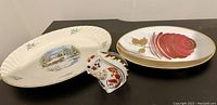 Photo showing two decorative dishes and a Crown Derby squirrel figurine on a black surface.