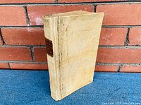 Front cover of vellum-bound book showing aged patina and slight warping