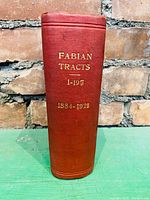 Front view of the spine of the cloth bound red antique book with gold embossed text 'Fabian Tracts 1-197 1884-1921'. Shows condition of spine and binding.