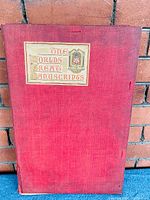 Front red textured cloth folio with label 'The World's Great Manuscripts' and emblem of The Colonial Press