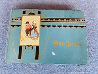 Full view of the album front cover showing decorative art, gold embossed text, and wear marks