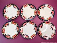 Six Windsor Derby dinner plates arranged in two rows showing floral and geometric decorative rim.