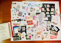 Loose stamps spread on table showing variety of denominations and designs