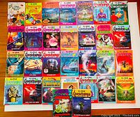 Top-down photo of about 30 vintage Goosebumps books arranged flat showing front covers and titles.