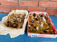 Two colorful boxes filled with assorted small Wade Red Rose Tea figurines including various animals in different poses.