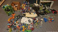 Overview of all items spread on floor including playset, vehicles and figures