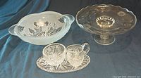 Photo showing all items: frosted serving bowl with rose pattern, etched glass pedestal cake plate, and pinwheel cut glass creamer, sugar bowl, and tray set.
