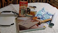 Lot items on a table: plastic cutting boards, pastry mat, wooden rolling pin, marble pastry board in box, Stendipasta dryer in box, Atlas 150 pasta maker box