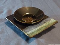 Two-piece flower arrangement container with rectangular base and round dish with flower frog, showing glaze and form.