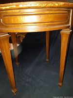 Close-up of the table legs showing tapered design and carved feet, wooden construction.