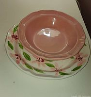 Top view of the pink bowl placed on the floral serving plate, showing shape and colors