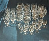 Full group of wildflower pattern crystal stemware and bowls arranged on dark cloth