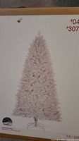 Box showing the assembled white Christmas tree on a stand with lights on, size 7 ft.