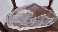 Top angled view of clear crystal sculpture with roaring male lion, lioness and cub in the center.
