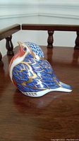 Front and side view of the Royal Crown Derby porcelain robin figurine.