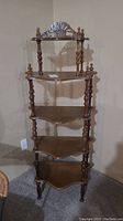 Full view of five-tier wooden shelving with turned supports, showing overall design and structure