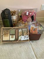 View of assorted toiletries including gift set with soaps, lotions, decorative bottles, and bath accessories in containers and bags.
