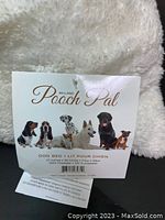 Close-up photo of the Millano Pooch Pal dog bed tag labeling the product size and material details.