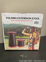 Box packaging of the folding extension stool with an outdoor scene and the product name.