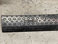 Black rubber curb ramp lying on concrete floor, showing textured anti-slip surface and embossed VEVOR logo