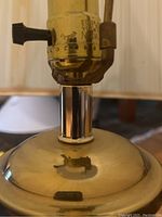 Close-up of lamp socket and brass base detail showing some wear and metal finish.