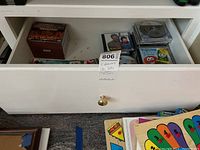 Drawer containing CDs and DVDs including children's music, movies, and other titles
