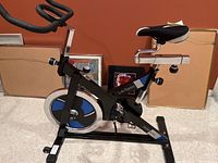 Full view of the black and blue LifeSpan Sport Series stationary bike showing frame, seat, pedals, and handlebars.