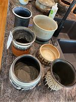 Six ceramic pottery pieces arranged together showing various glaze styles and colors.