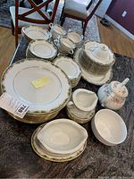 Full view of Noritake china set including plates, cups, creamer, the Sadler floral teapot and utility bowl on a table.